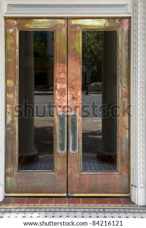 Crafty brass door with windows with street reflection