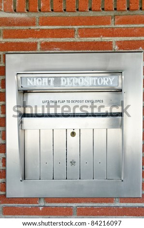 Stainless steel depository box on brick bank wall