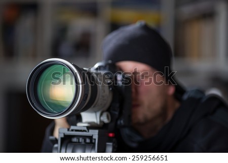 Man taking pictures with large telephoto lens