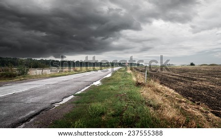 Road in a cloudy weather against thunderclouds