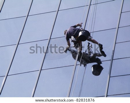 A man cleaning windows on a high rise building