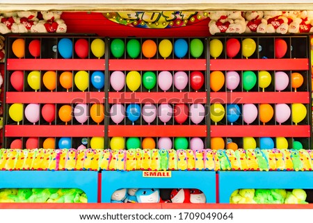 Similar – Image, Stock Photo Throwing booth at the fair with colorful balloons and throwing arrows and blue background