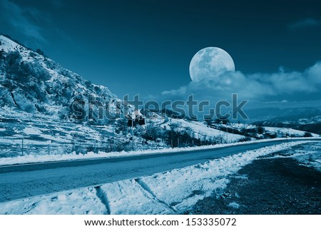 mountain road in the evening with moon in the sky