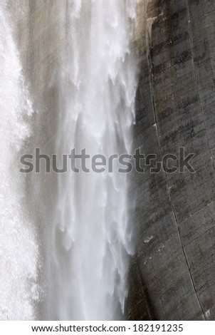 Water falls from the wall of the  dam