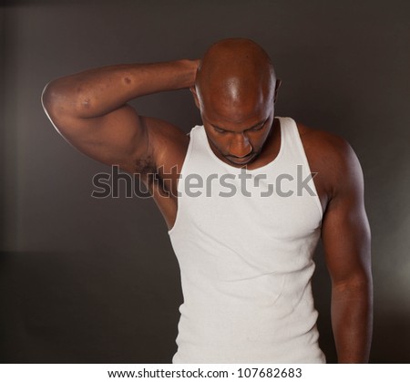 Young, handsome, muscular black man in a t-shirt looking down
