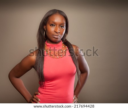 Fashion forward African American woman with part American Indian heritage in a pink dress with jewelry