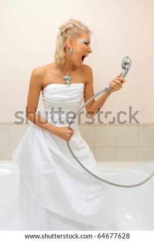 Fashion model in wedding dress cries in the bathroom