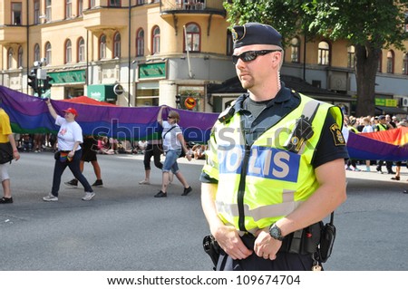 STOCKHOLM, SWEDEN - AUGUST 4: An unidentified policeman protects people taking part in Pride Parade 2012 to support gay rights on August 4, 2012 in Stockholm Sweden.