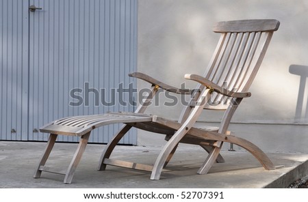 Lounge chair against a wall and a blue door.