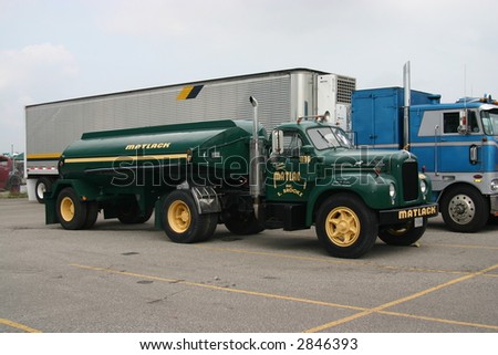 dark green side view of a Matlack fuel tanker truck and trailer, from a truck show