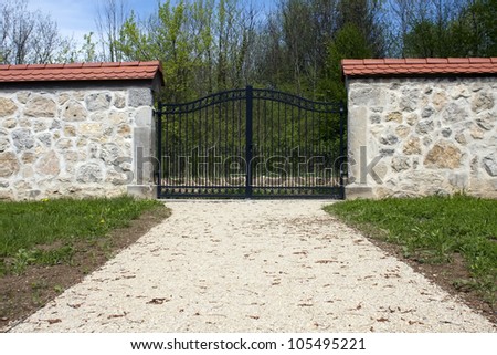 Wall with iron entrance gate and path.