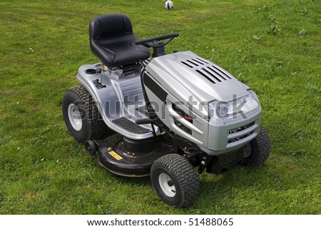 Small tractor for cutting grass. All logos removed. Warning signs left.