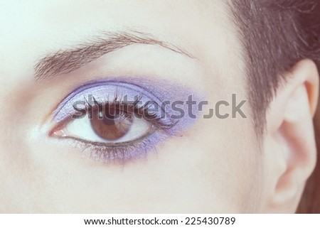 Macro picture of the eye of a woman with blue make-up