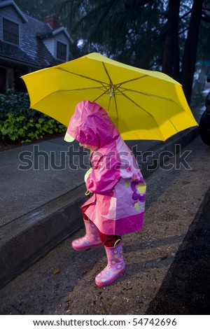 Little Girl With Yellow Umbrella Playing In Rain Wearing Pink Rain ...