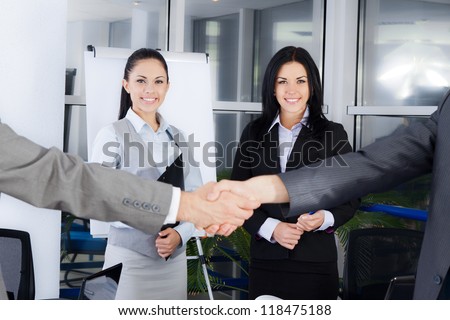 Business handshake with business people smile on background, colleagues shaking hands during meeting after signing agreement in office