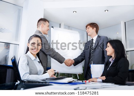 Business people handshake, businessmen hand shake on background, during meeting after signing agreement in office, businesswoman at desk smile