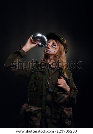 army girl hold flask water bottle, thirsty soldier woman drink in a military uniform over black background