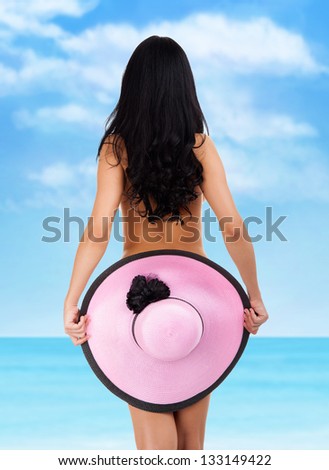 Rear view back of young beautiful woman brunette wearing summer beach hat and bikini cover ass back, concept of travel holiday over sea tropical ocean blue sky vacation