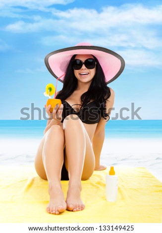 summer vacation woman lying on beach yellow sand towel smile drink tropical cocktail with straw, sun tanned body, girl wear pink hat, sunglasses, over sea blue sky, concept holiday travel