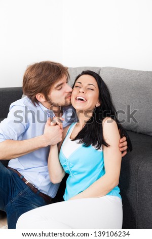 young couple kiss on couch, romantic love happy excited smile, lovely man kissing woman embrace on the sofa, lover