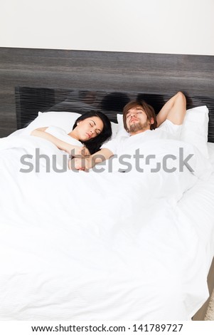 young couple sleep in bed, man and woman with closed eyes lying in bedroom