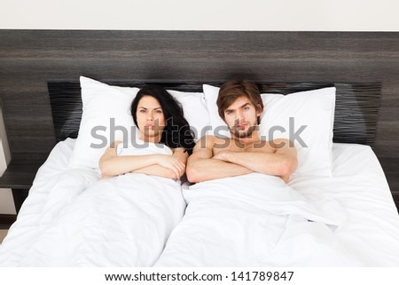 unhappy separate couple lying in a bed, man and woman having conflict problem cheat, upset sad negative emotions concept