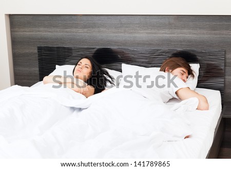unhappy separate couple lying in a bed, having conflict problem cheat, upset sad negative emotions concept