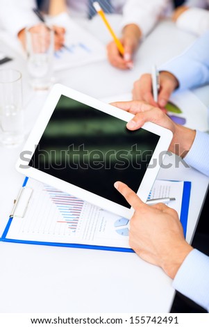 Businessman holding digital tablet, touching hand point finger touch screen, business people group desk office, conference, businesspeople meeting report financial charts