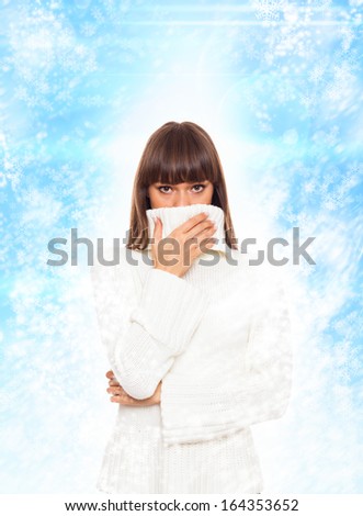 sick woman sneezing got flu or cold, cover mouth by hand, wear warm winter sweater, abstract christmas ornament with blowing snow flake blue background