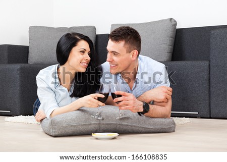 young couple drink red wine toast, happy smile, lovely young man and woman love, romantic celebrate hold glass, at home in living room