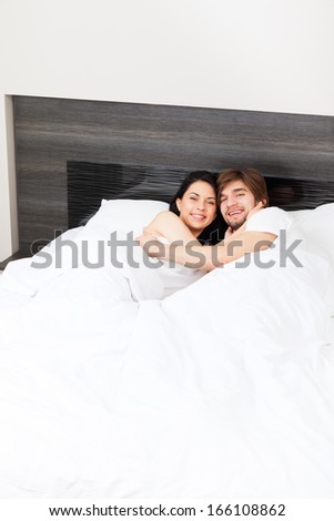 young couple in bed, happy smile man and woman lying in bedroom