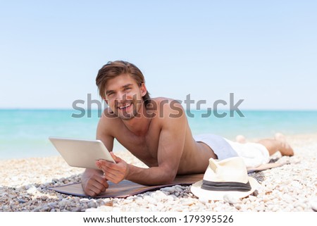 man use tablet computer lying on beach, smile summer vacation, Handsome young male, sun tanned body, guy over sea blue sky, ocean holiday travel
