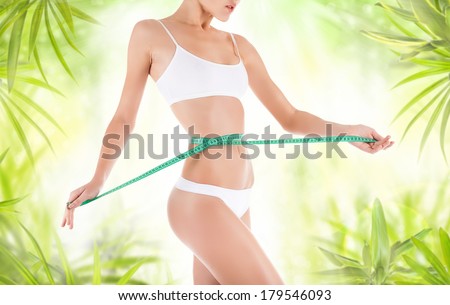 woman measure waist, perfect slim body figure, female measuring tape size of belly.  background, fitness concept, over green leaf background
