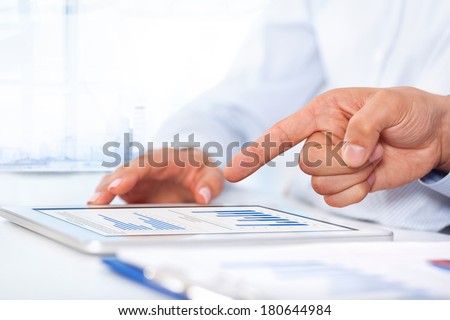 Businessman analyzing graph using digital tablet touch pad, touching hand point finger touch screen, business people group desk office, businesspeople report financial charts