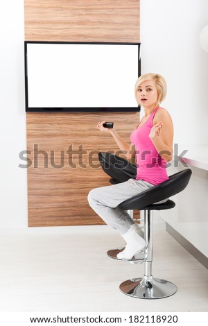 woman watching tv negative emotion scared, terrified hold remote control changing channel, shock fear girl in living room at home, isolated screen empty copy space
