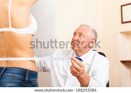 doctor examine woman waist measure with tape, plastic surgery