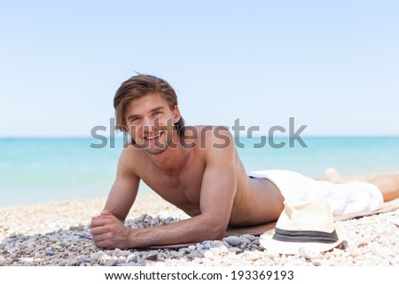 man smile lying tanning rest on beach, handsome male sunbathing summer vacation, sun tanned body, guy over sea blue sky, ocean holiday travel