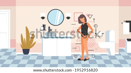 woman testing skin presence of stretch marks checking cellulite on her buttock girl clamping fat fold on hip diet weight loss concept bathroom interior full length horizontal