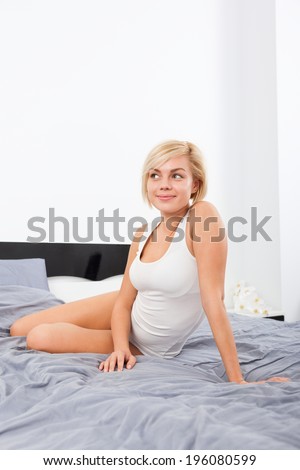 smiling woman dream looking up copy space, sitting on bed in bedroom, happy girl morning wake up smile, underwear