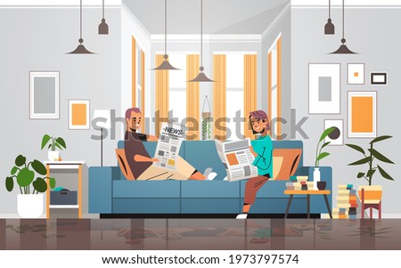 couple holding newspapers man woman sitting n sofa reading daily news press mass media concept