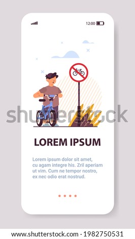 schoolboy with bicycle standing near red round kike ban sign road safety concept vertical