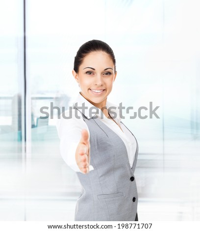 businesswoman handshake, hold hand welcome gesture, young excited business woman happy smile in modern office