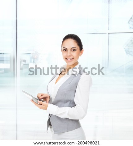 business woman happy smile hold tablet pad computer empty touch screen with copy space, young businesswoman wear vest smiling in modern office