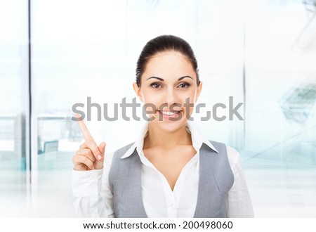 Businesswoman smile point finger to empty copy space, business woman showing pointing side, concept of advertisement product in modern office