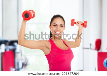 sport fitness woman in gym, young healthy girl smile gym exercises dumbbells working out