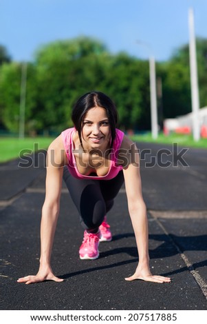 Woman smile start position on stadium, ready to run summer outdoor training