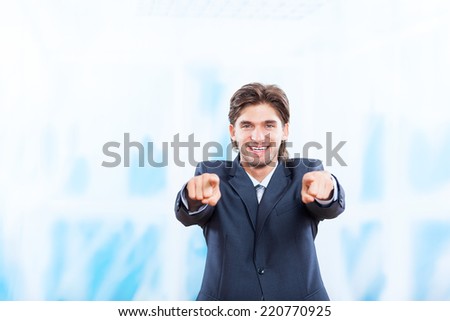 young business man point finger at you happy smile in bright blue office, Handsome businessman wear elegant suit and tie