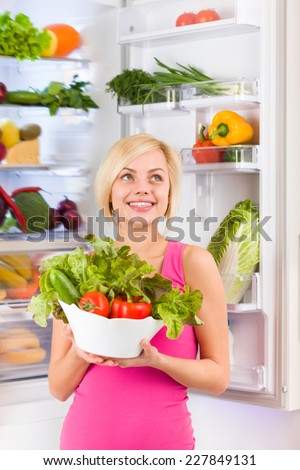 woman hold raw fresh vegetables refrigerator, diet healthy organic vitamin food concept, pretty girl smile at home modern kitchen