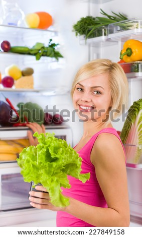 young woman hold fresh green salad diet, refrigerator open door, pretty girl dieting healthy food vegetables and fruits