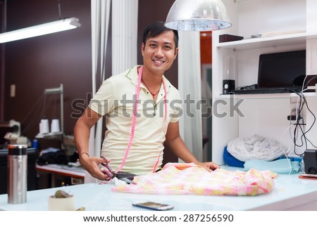 Asian man tailor fashion clothes dress designer working with fabric on table